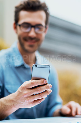 Buy stock photo Shot of a young man using a cellphone outdoors