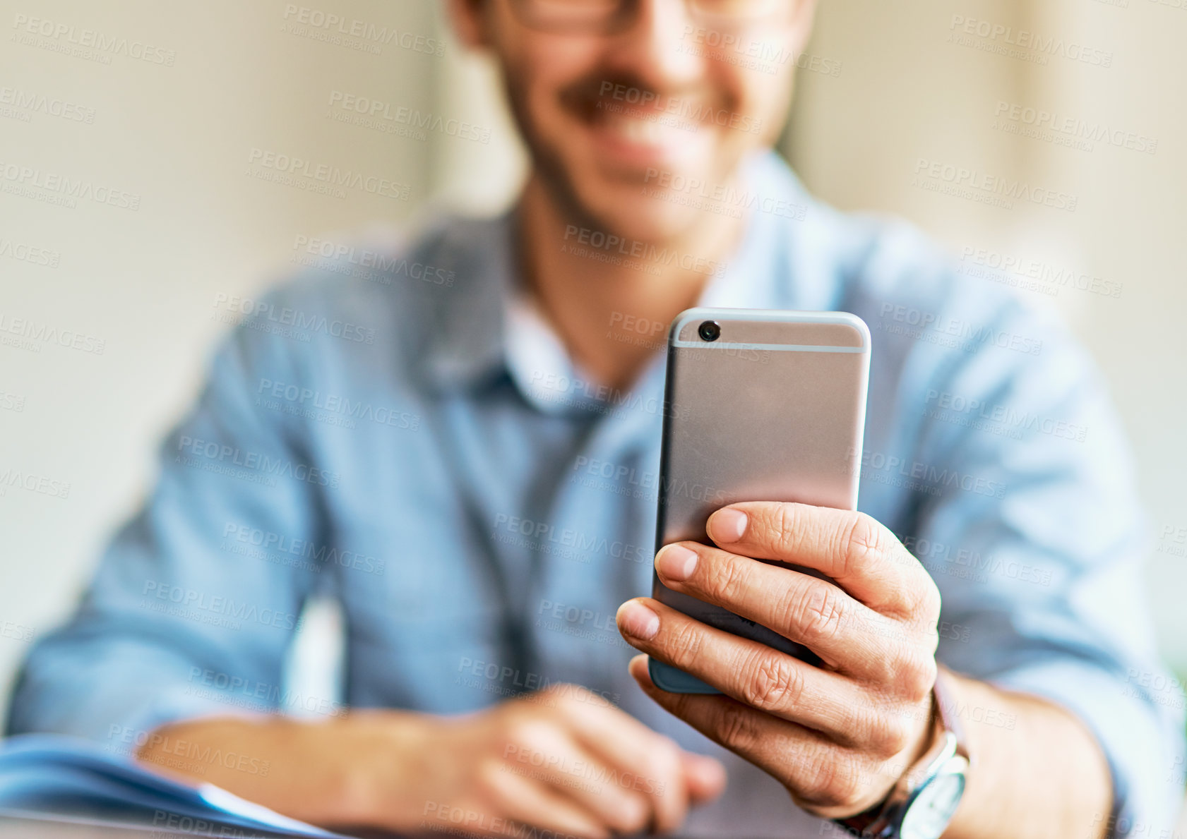 Buy stock photo Shot of a young man using a cellphone at home