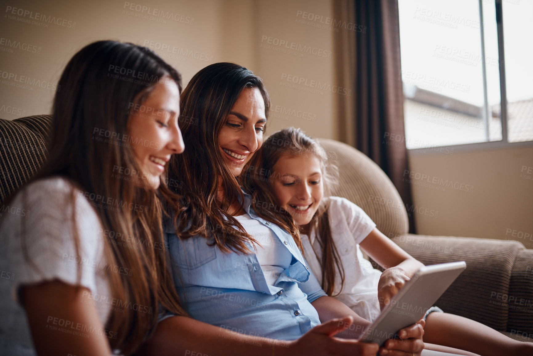 Buy stock photo Cropped shot of an attractive mother watching movies on a tablet with her two daughters at home