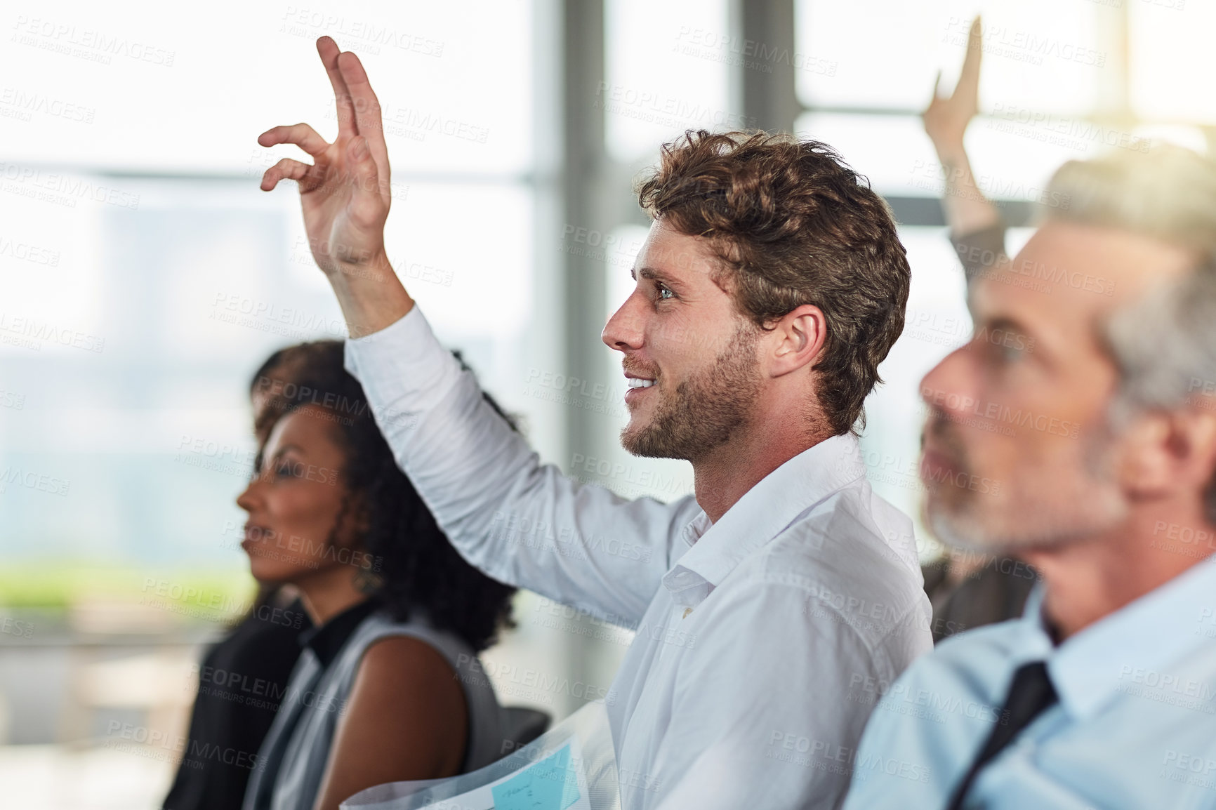 Buy stock photo Cropped shot of a handsome young businessman raising his hand during a seminar
