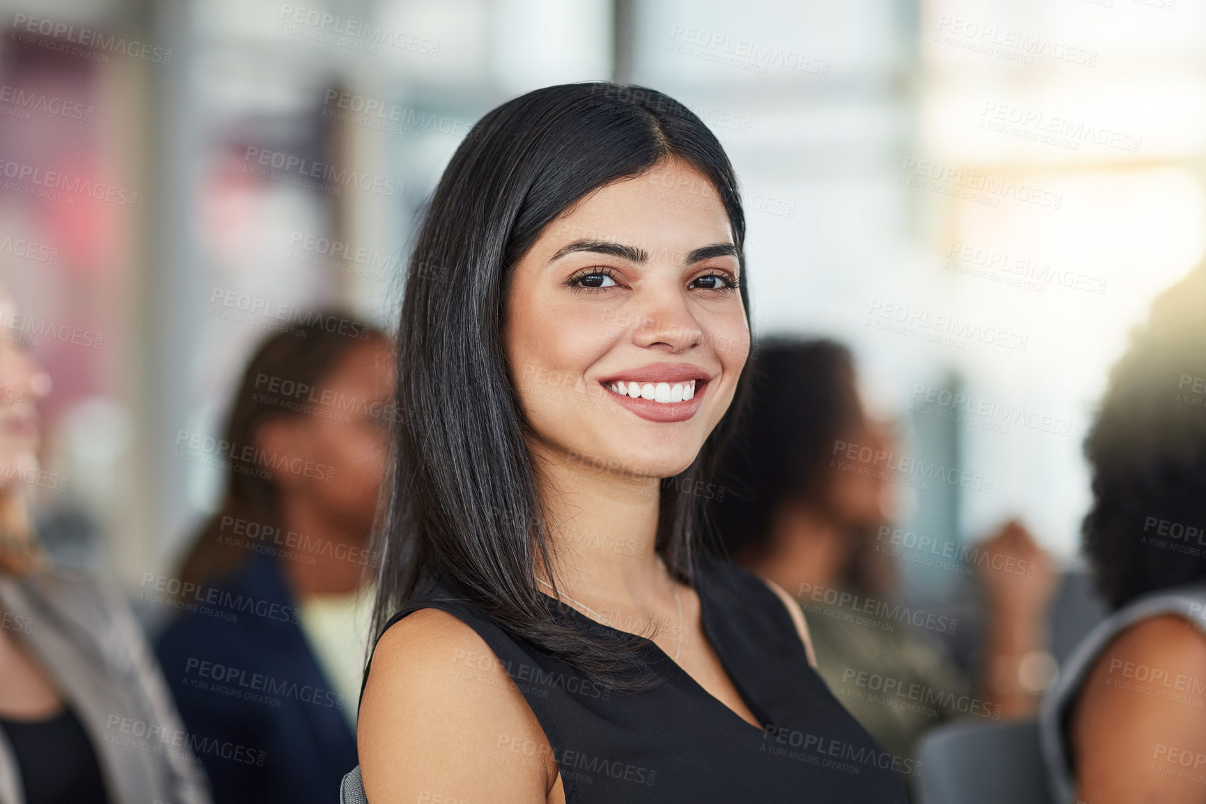 Buy stock photo Cropped portrait of an attractive young businesswoman attending a seminar with her colleagues