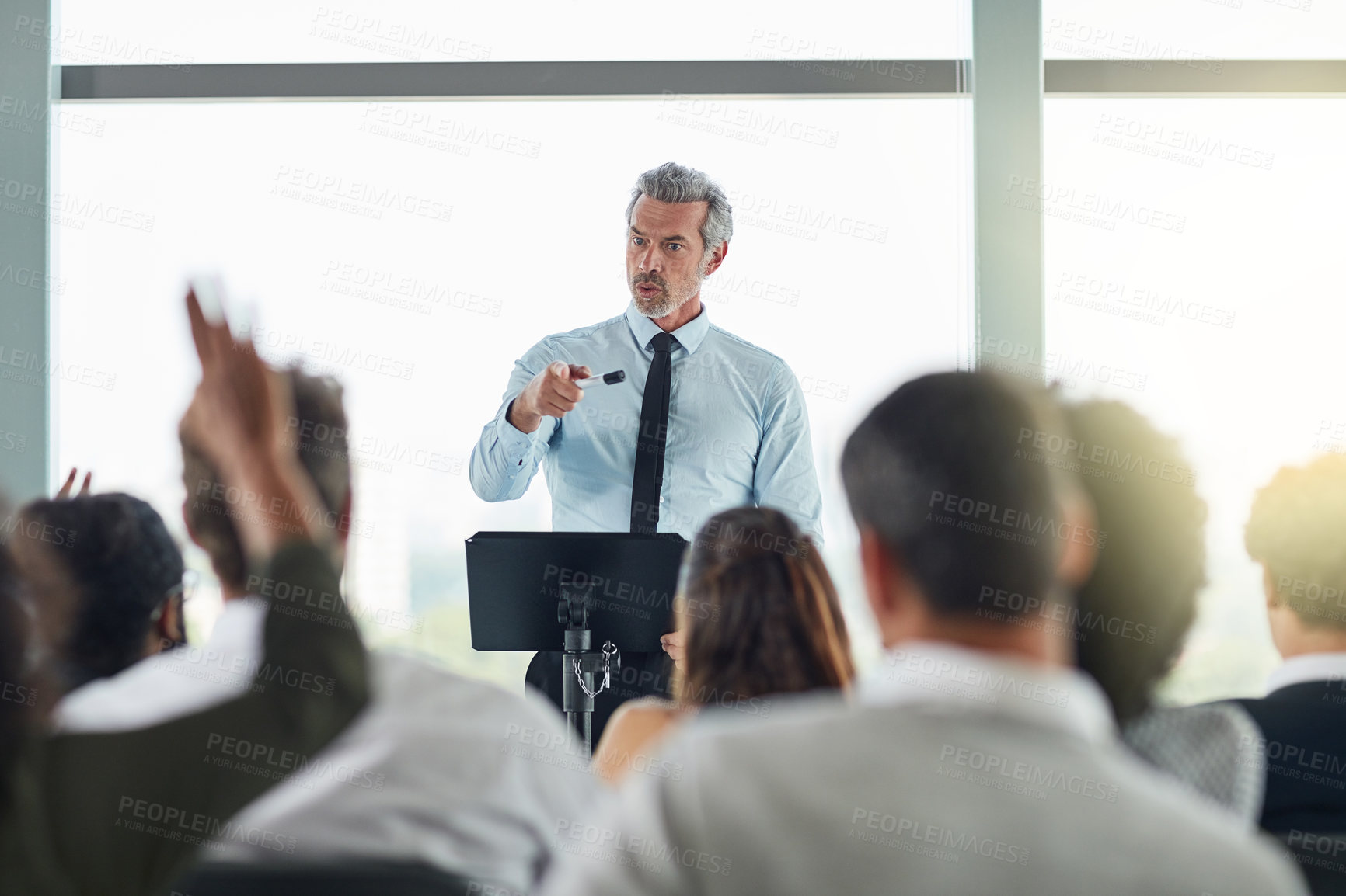 Buy stock photo Podium, mature man and question in seminar, speaker and audience in event, training and presentation in boardroom. Workshop, speech and talking in conference, entrepreneurship and masterclass