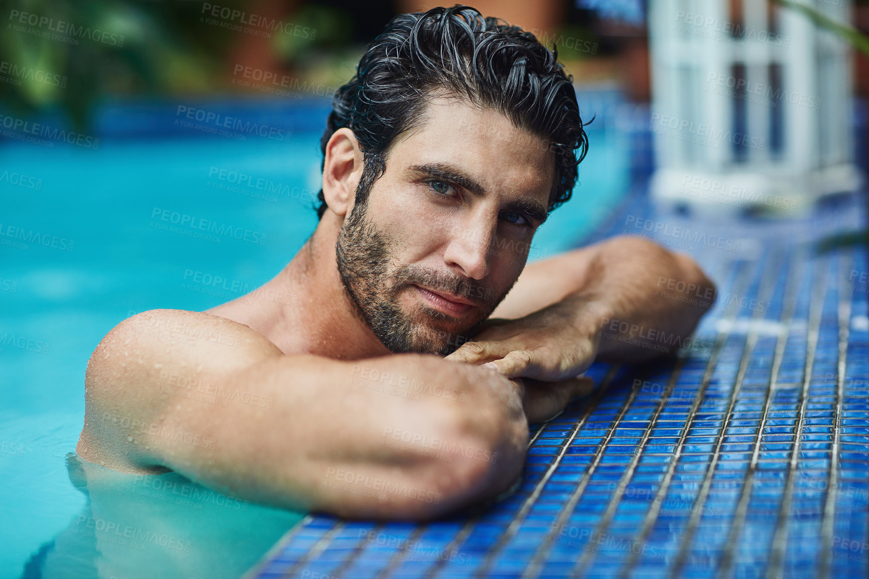 Buy stock photo Cropped shot of a handsome young man in the swimming pool at home
