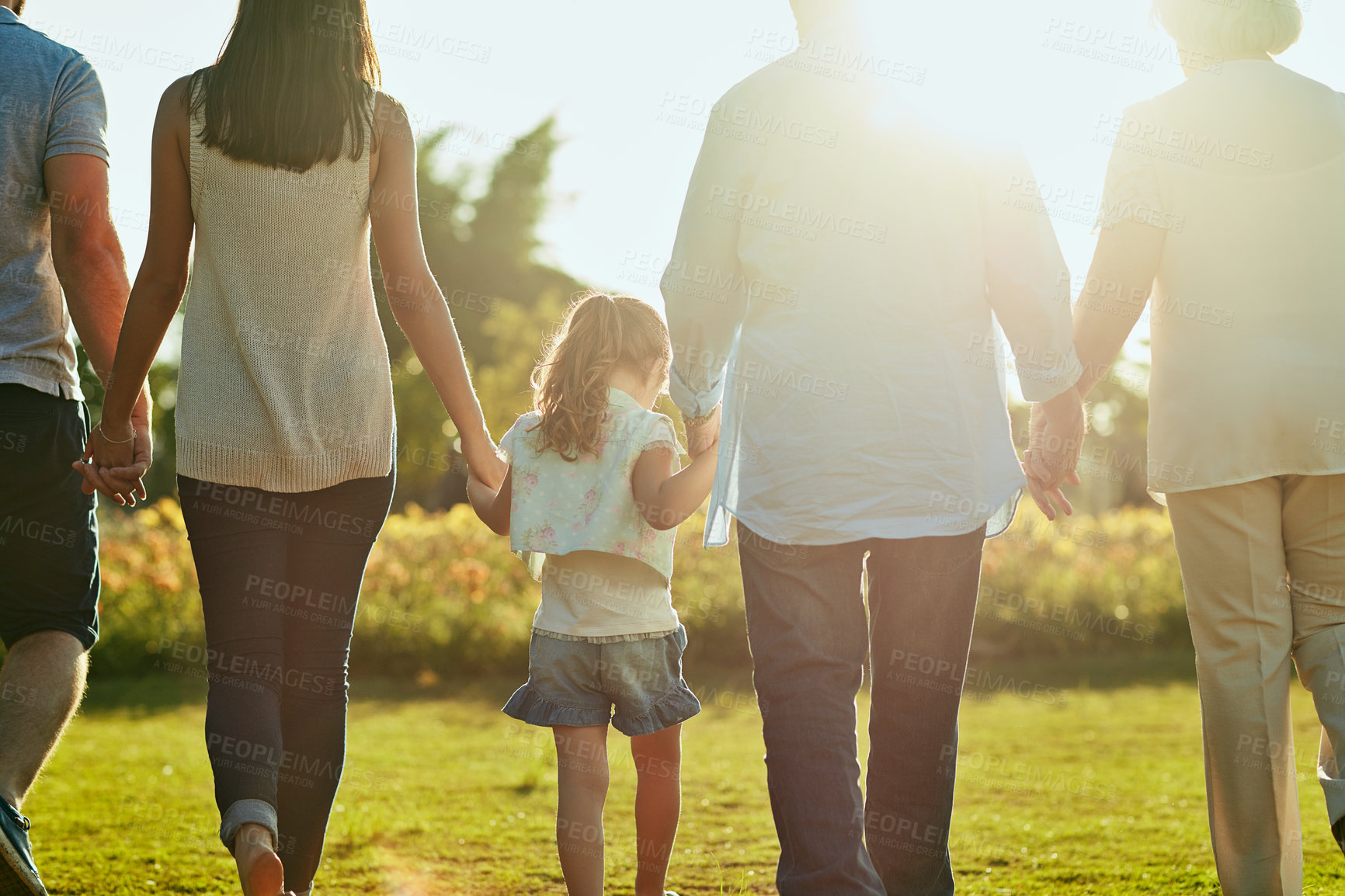 Buy stock photo Rearview shot of a family going for a walk together in the park