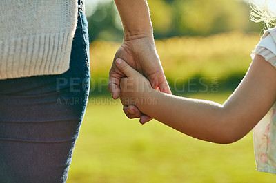 Buy stock photo Cropped shot of a little girl holding an unrecognizable woman’s hand in the park