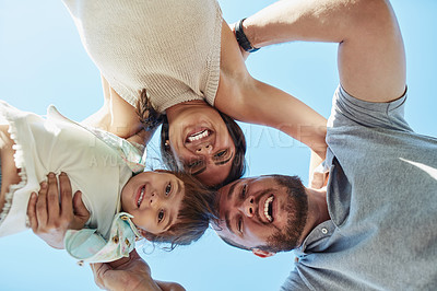 Buy stock photo Low angle portrait of a happy family huddled together outdoors