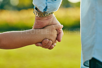 Buy stock photo Cropped shot of a little girl holding an unrecognizable man’s hand in the park