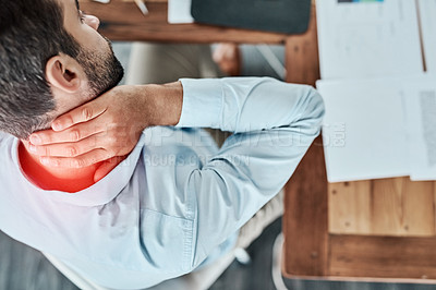 Buy stock photo High angle shot of a young businessman suffering with neck pain while working in an office