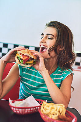 Buy stock photo Restaurant, bite and woman with burger, fast food and hungry for meal in weekend. Cafeteria, happy girl and cheese sandwich and nutrition as comfort snack, eating and tasty bun of female person