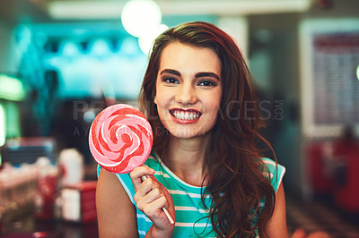 Buy stock photo Cropped portrait of an attractive young woman eating a giant lollipop in a retro diner