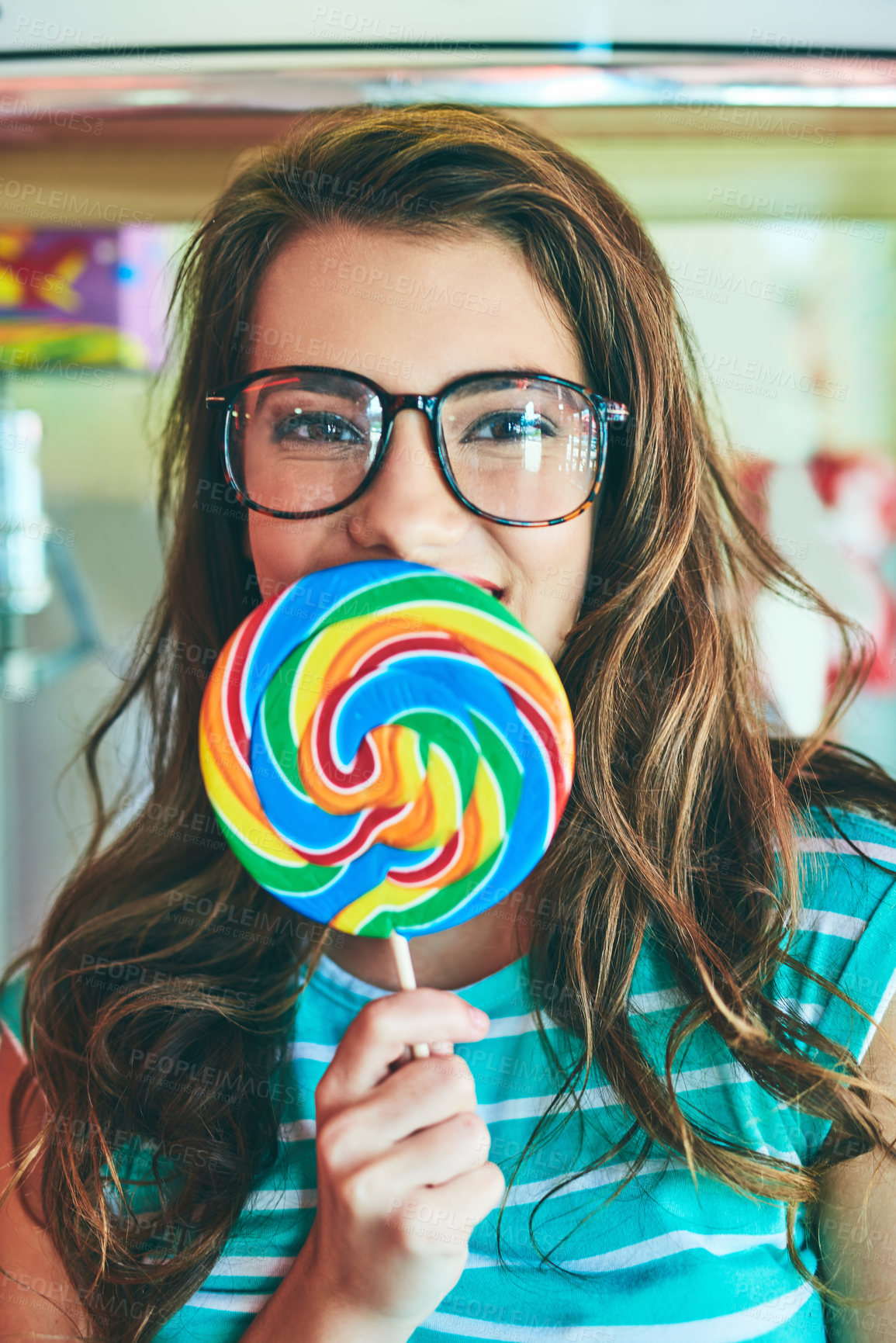 Buy stock photo Cropped portrait of an attractive young woman eating a giant lollipop in a retro diner