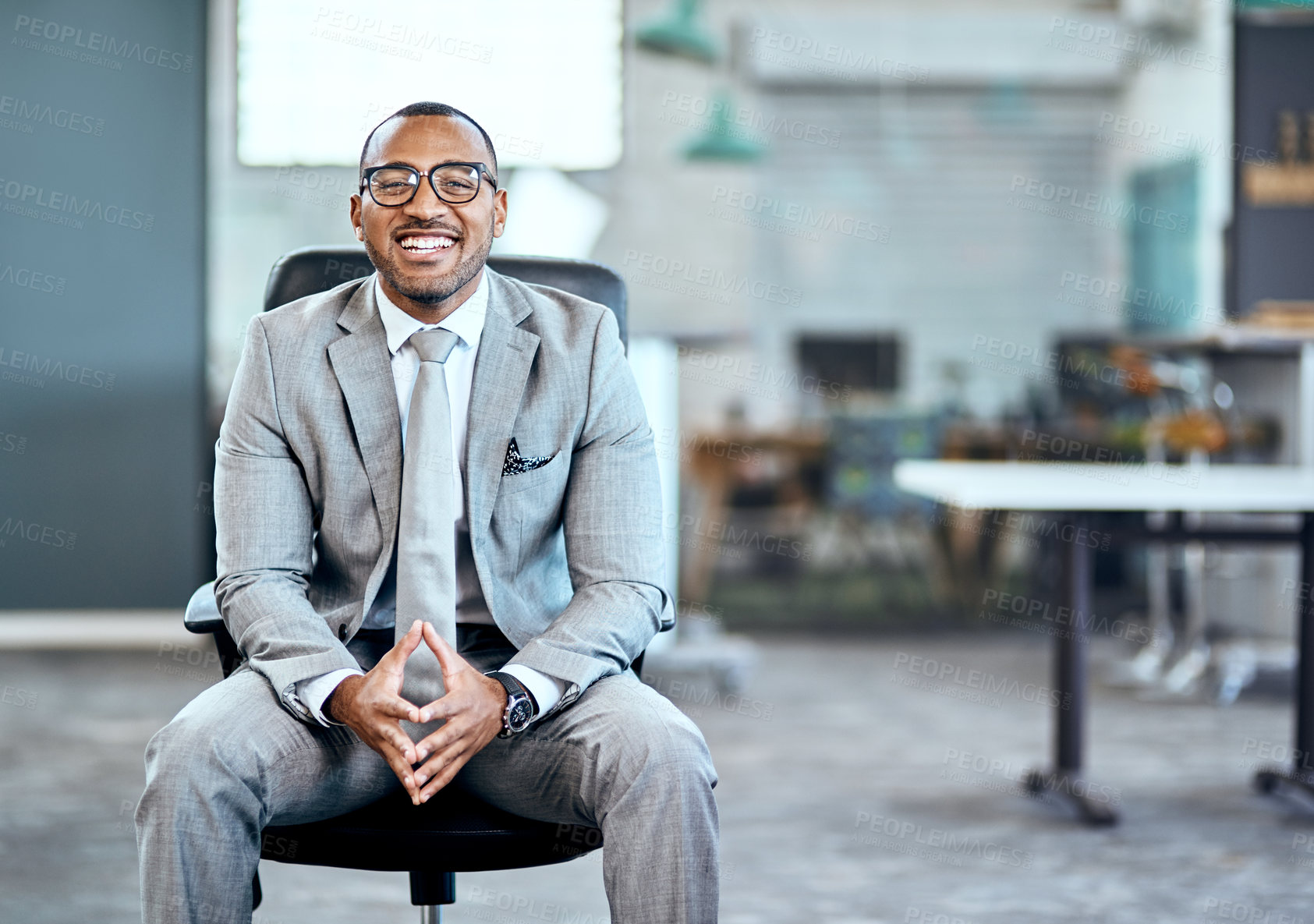 Buy stock photo Portrait of a young businessman sitting on a chair in an office
