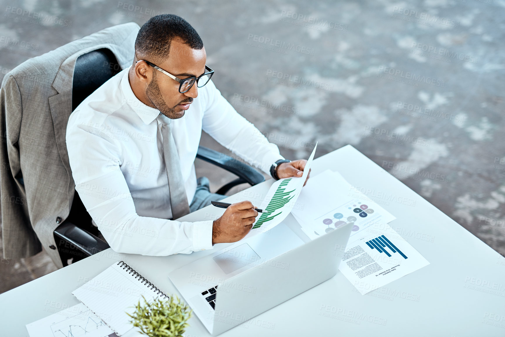 Buy stock photo Financial analyst, focus and black businessman planning in an office or reading report and employee on desk. Serious, corporate worker and graphs or revenue documents or laptop and stats data at work