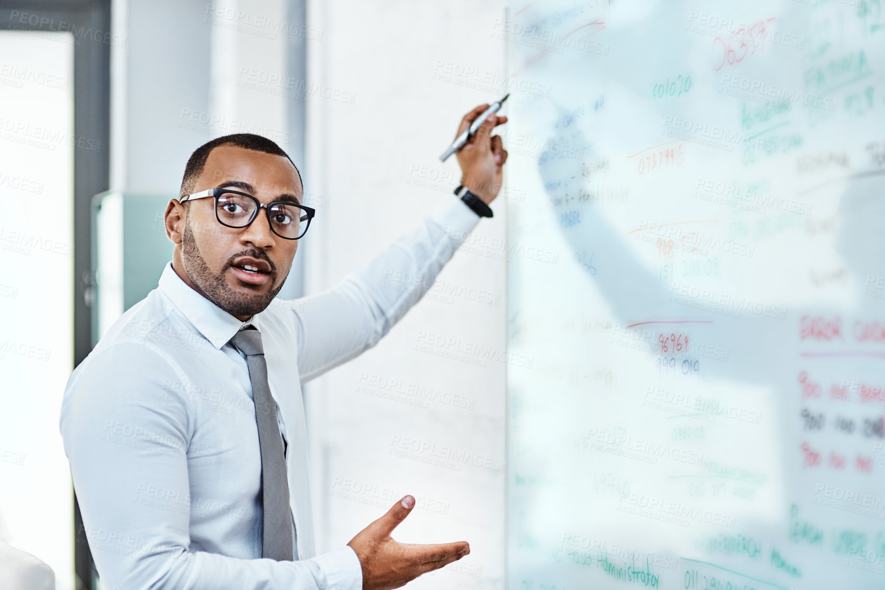 Buy stock photo Portrait of a young businessman brainstorming on a whiteboard in an office