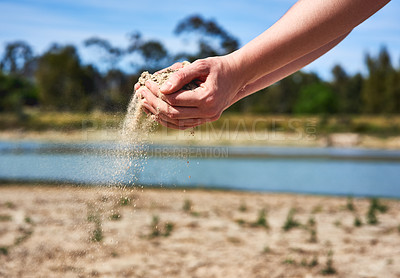 Buy stock photo Shot of an unrecognizable person holding two hands full of sand showing how dry the area is outside