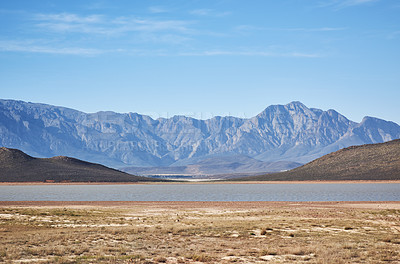 Buy stock photo Shot of a desolate landscape during the day with a small dried out dam in the middle