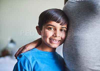 Buy stock photo Cropped portrait of an adorable little boy standing against his mother's pregnant belly
