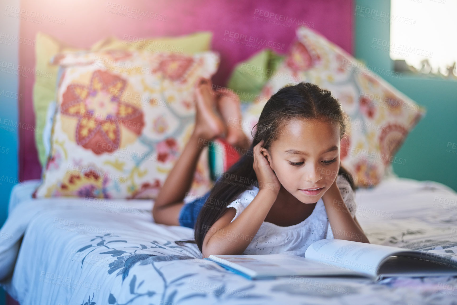 Buy stock photo Shot of an adorable little girl reading a book at home