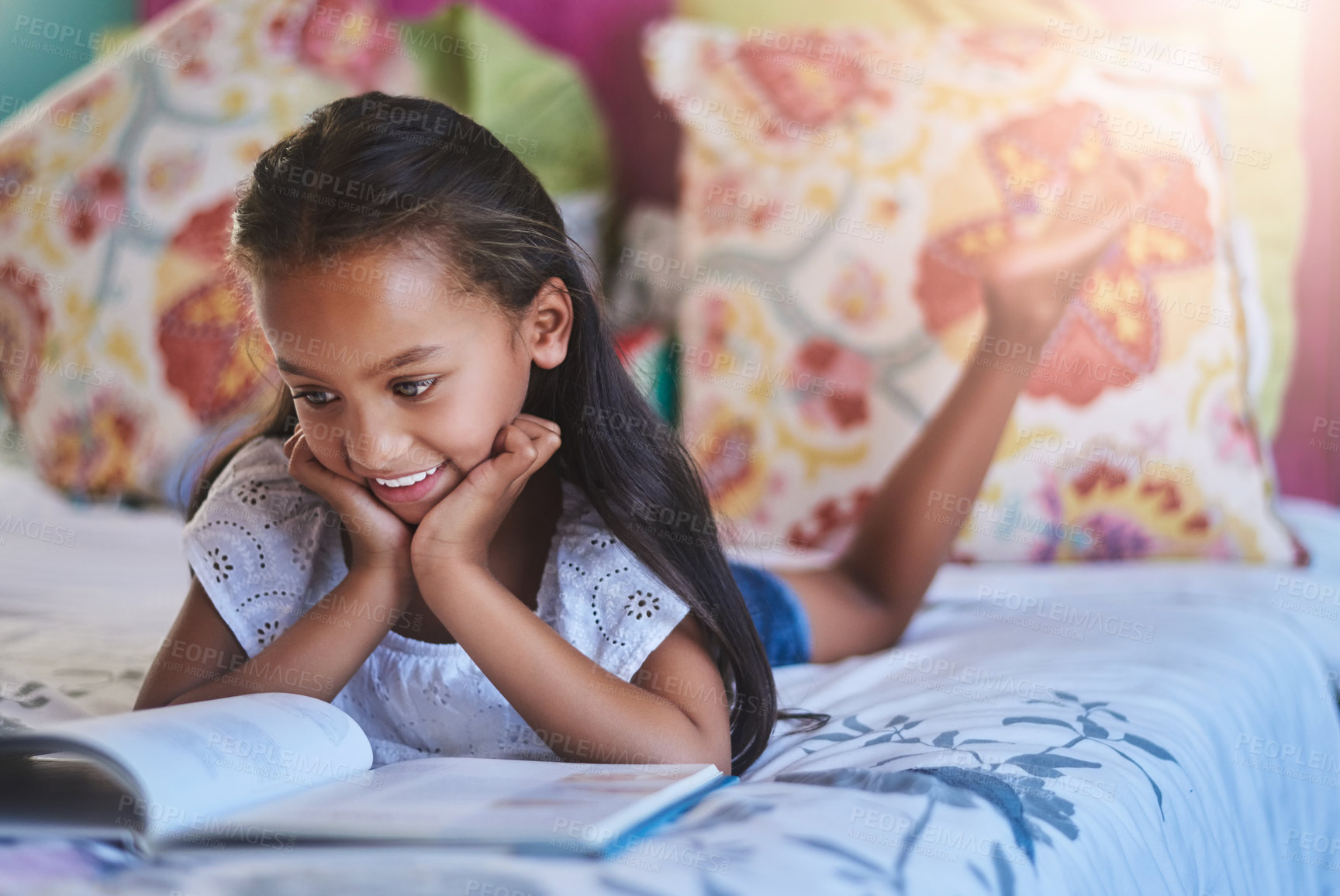 Buy stock photo Shot of an adorable little girl reading a book at home