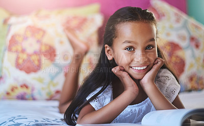 Buy stock photo Portrait of an adorable little girl reading a book at home