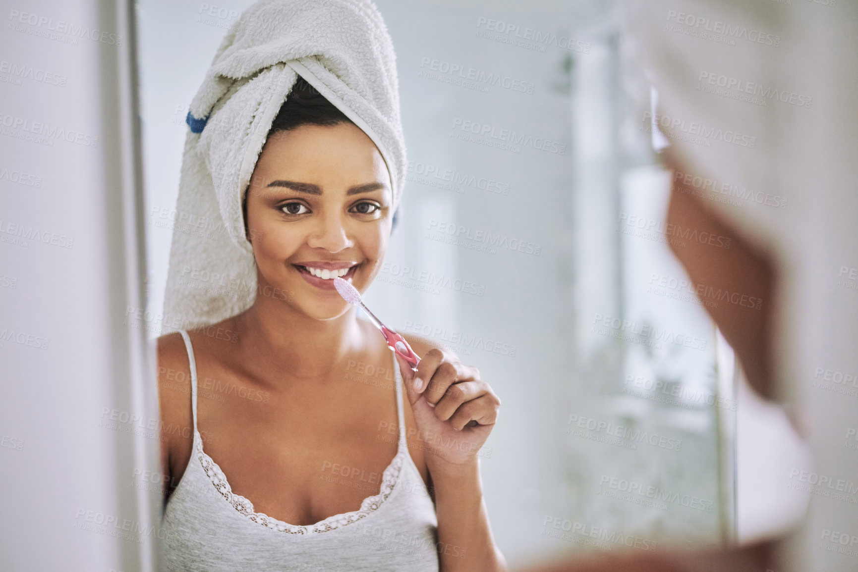 Buy stock photo Portrait of an attractive young woman brushing her teeth in the bathroom