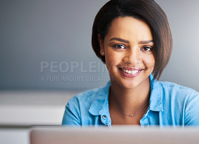 Buy stock photo Shot of an attractive young woman using a laptop at home against a gray background
