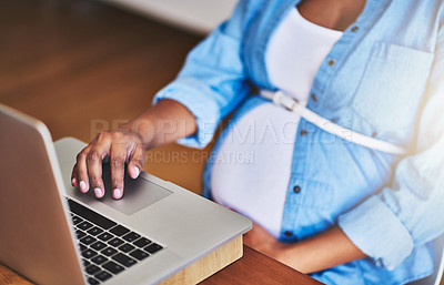 Buy stock photo Cropped shot of a pregnant woman using a laptop while working from home