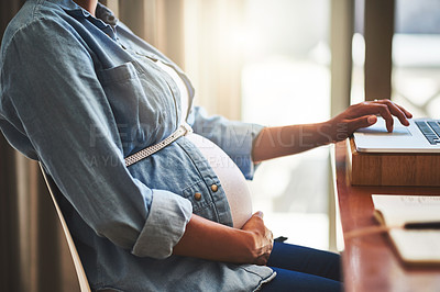 Buy stock photo Cropped shot of a pregnant woman using a laptop while working from home