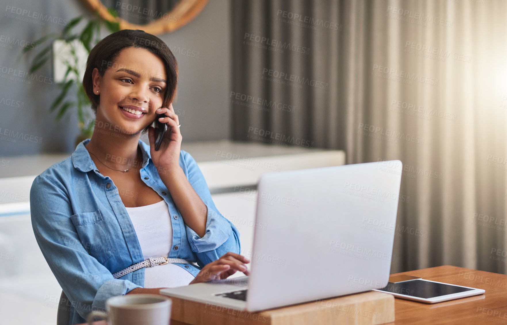 Buy stock photo Shot of a pregnant young woman using a laptop and mobile phone while working from home