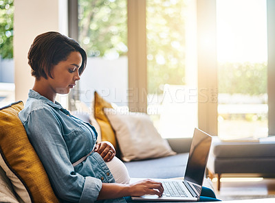 Buy stock photo Shot of a pregnant young woman using her laptop at home