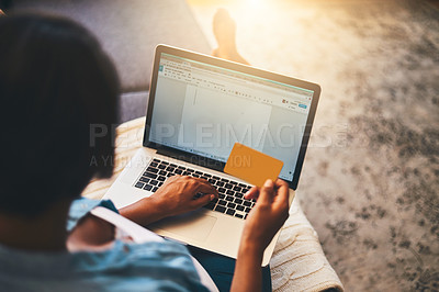 Buy stock photo Shot of a young woman using a laptop and credit card on the sofa at home