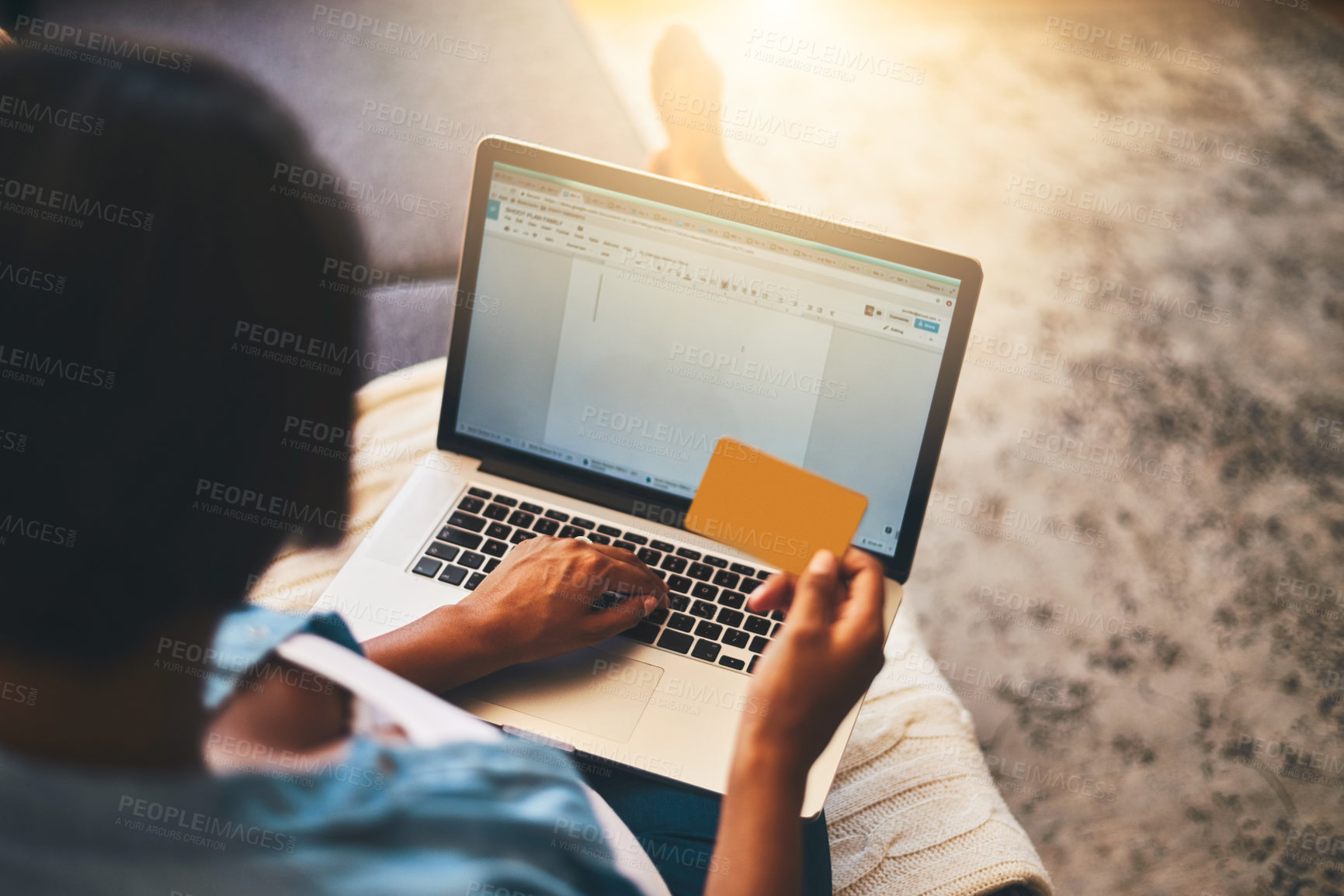 Buy stock photo Shot of a young woman using a laptop and credit card on the sofa at home