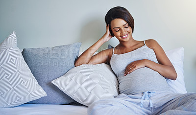 Buy stock photo Shot of a pregnant young woman relaxing on the bed at home