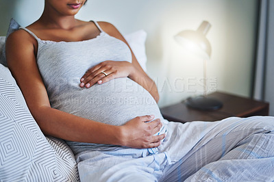 Buy stock photo Cropped shot of a pregnant young woman relaxing on the bed at home