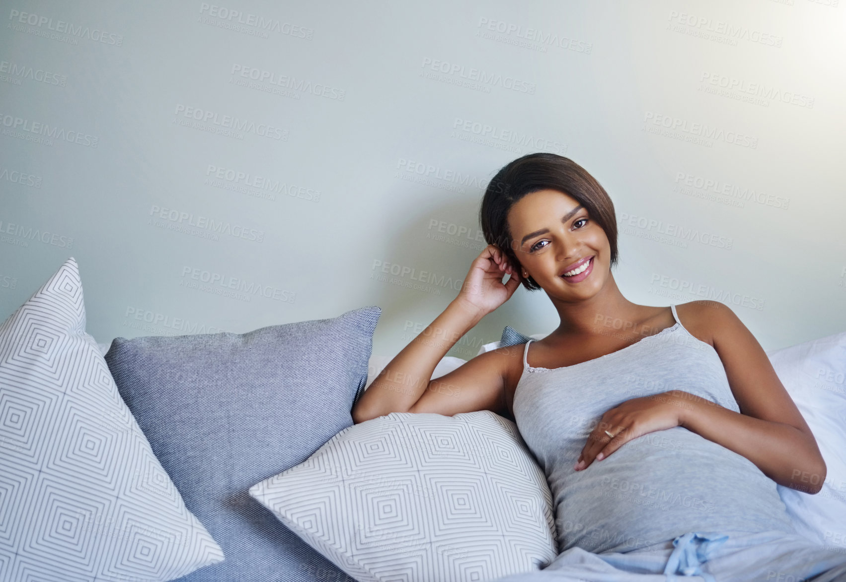 Buy stock photo Shot of a pregnant young woman relaxing on the bed at home