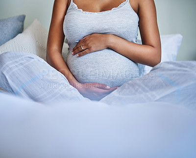 Buy stock photo Cropped shot of a pregnant young woman relaxing on the bed at home