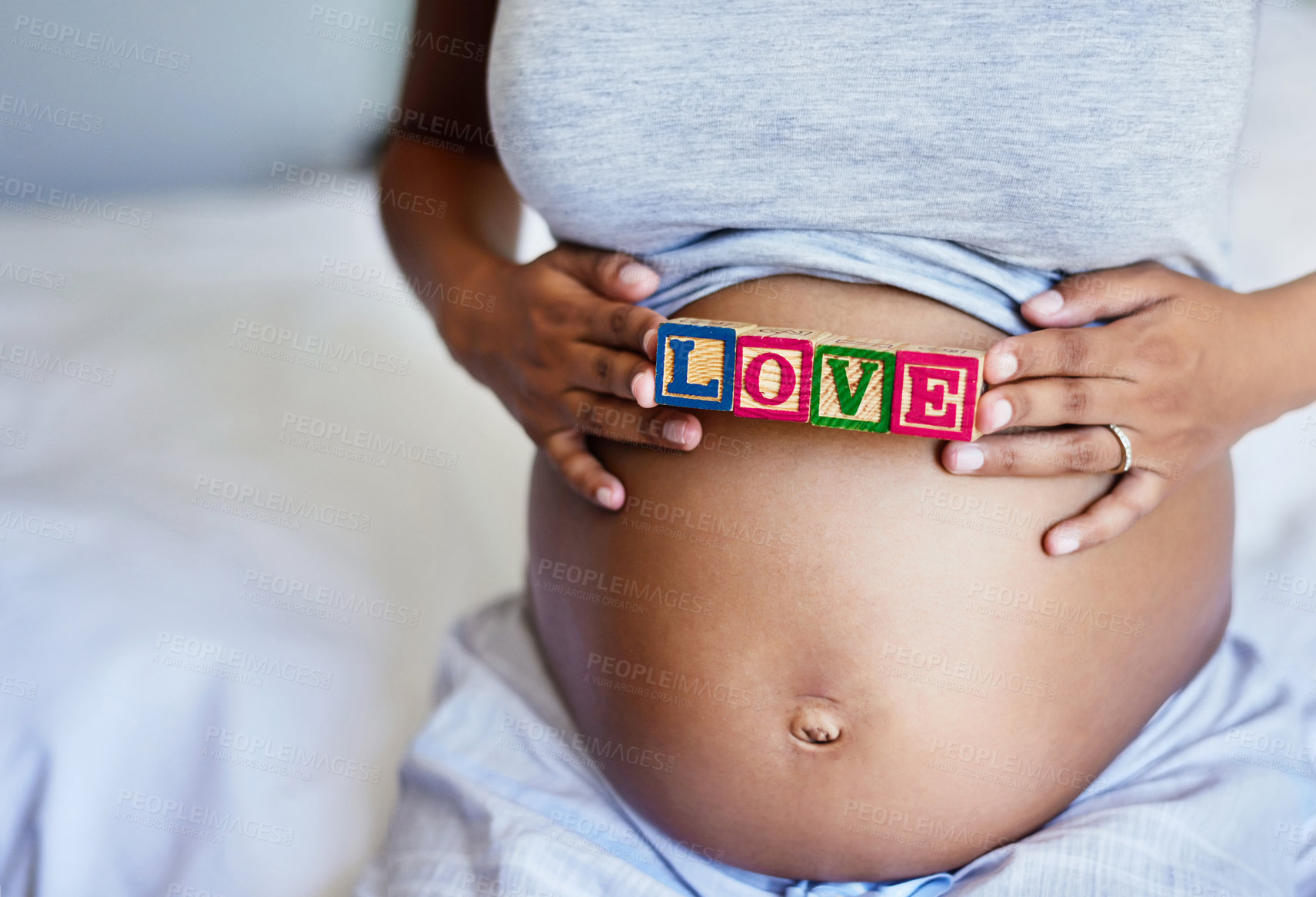 Buy stock photo Cropped shot of a pregnant woman with wooden blocks on her belly that spell the word love