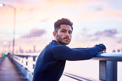Buy stock photo Portrait of a sporty young man taking a break while exercising outdoors