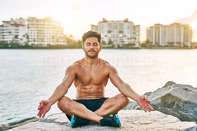 Buy stock photo Shot of a handsome young man meditating outdoors