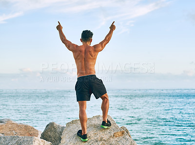 Buy stock photo Rearview shot of a handsome young man celebrating while exercising outdoors