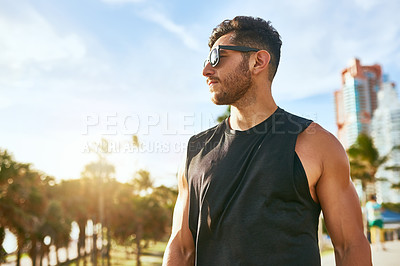 Buy stock photo Shot of a sporty young man standing outdoors