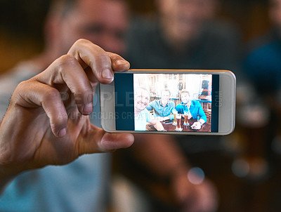 Buy stock photo Shot of  three young men drinking beer at a table while taking a self portrait together inside of a beer brewery