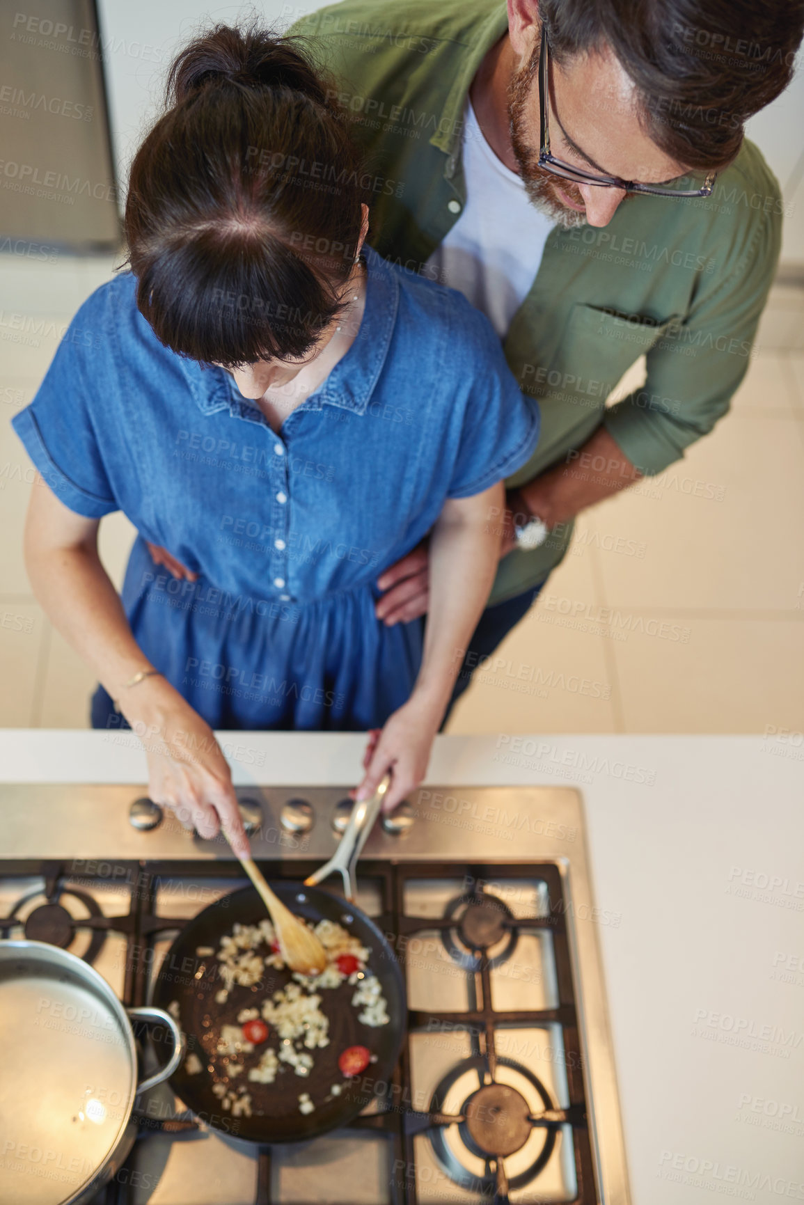 Buy stock photo High angle shot of a mature couple cooking together at home