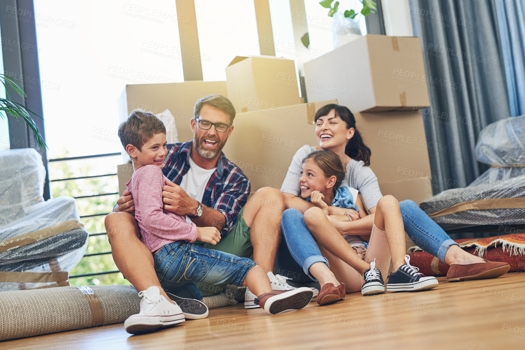 Buy stock photo Children, parents and laughing in apartment with box on living room floor with happiness for lifestyle. Family, boxes and excited in new house with investment in a mortgage for saving and wealth.