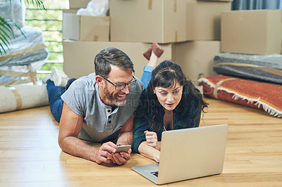 Buy stock photo Shot of a husband and wife using a laptop together on moving day