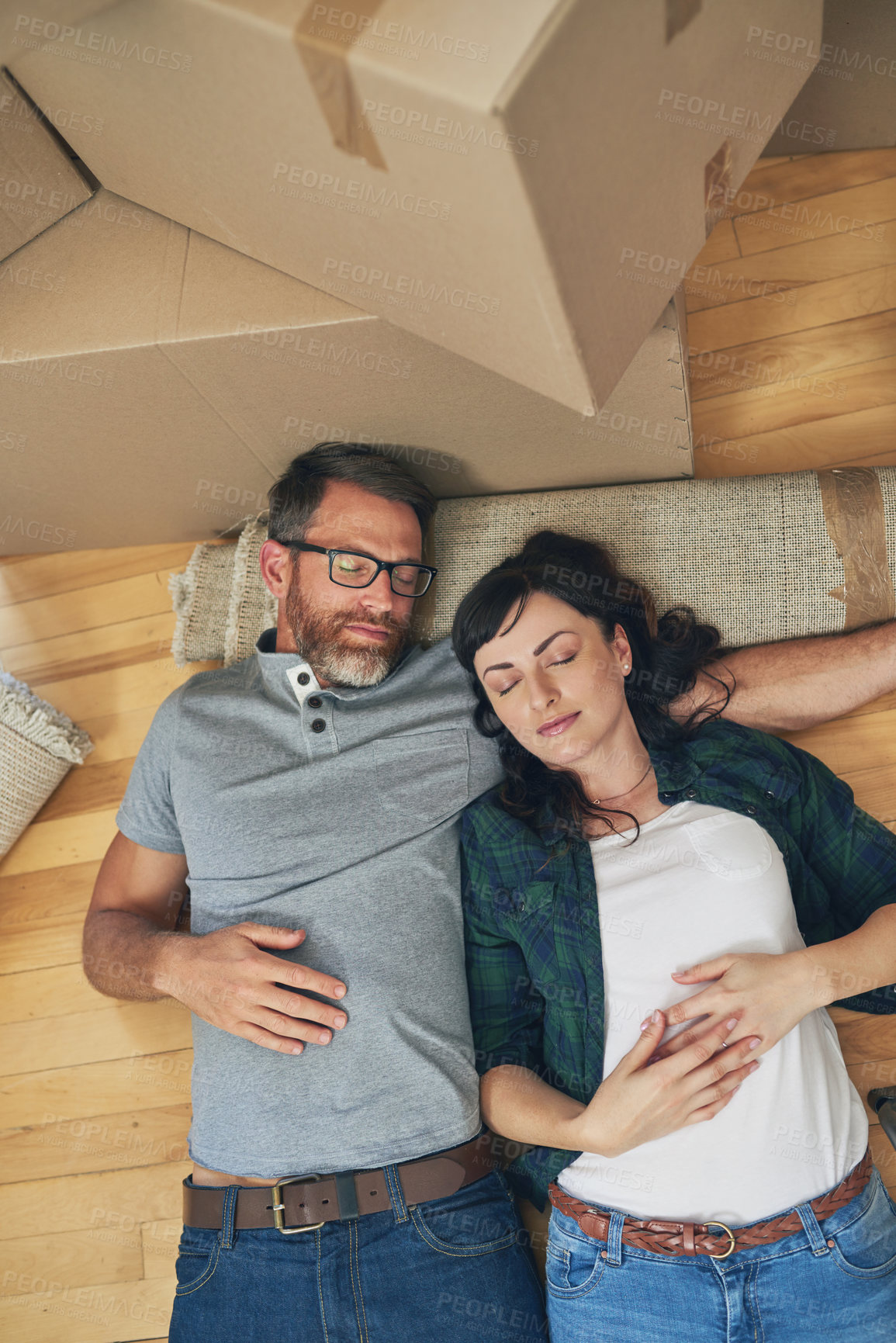 Buy stock photo High angle shot of a couple taking a nap together on moving day