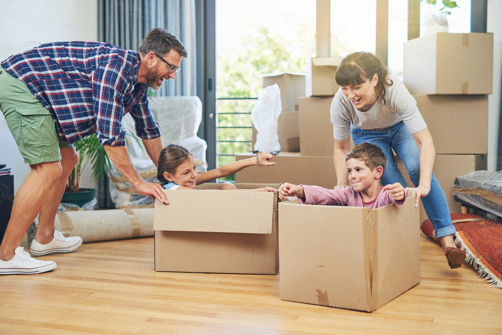 Buy stock photo Child, happiness and boxes with family moving in apartment for fun and enjoyment on the floor. Parents, happy and children excited in a box at family home for investment and a lifestyle with love.