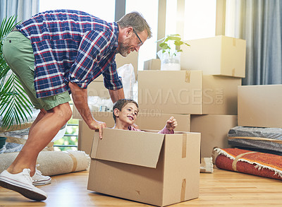 Buy stock photo Shot of a happy father and son having fun together on moving day