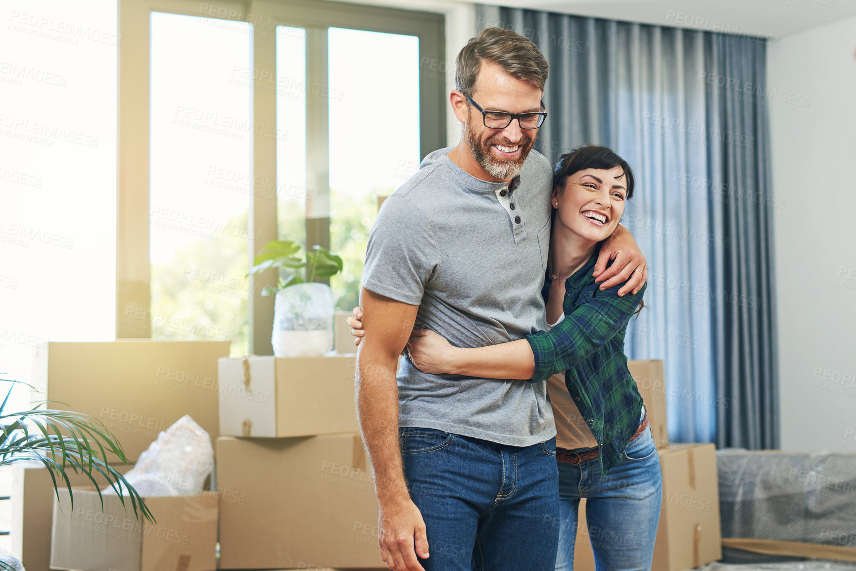 Buy stock photo Shot of a happy couple embracing in their home on moving day