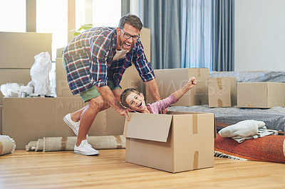 Buy stock photo Shot of a happy father and son having fun together on moving day